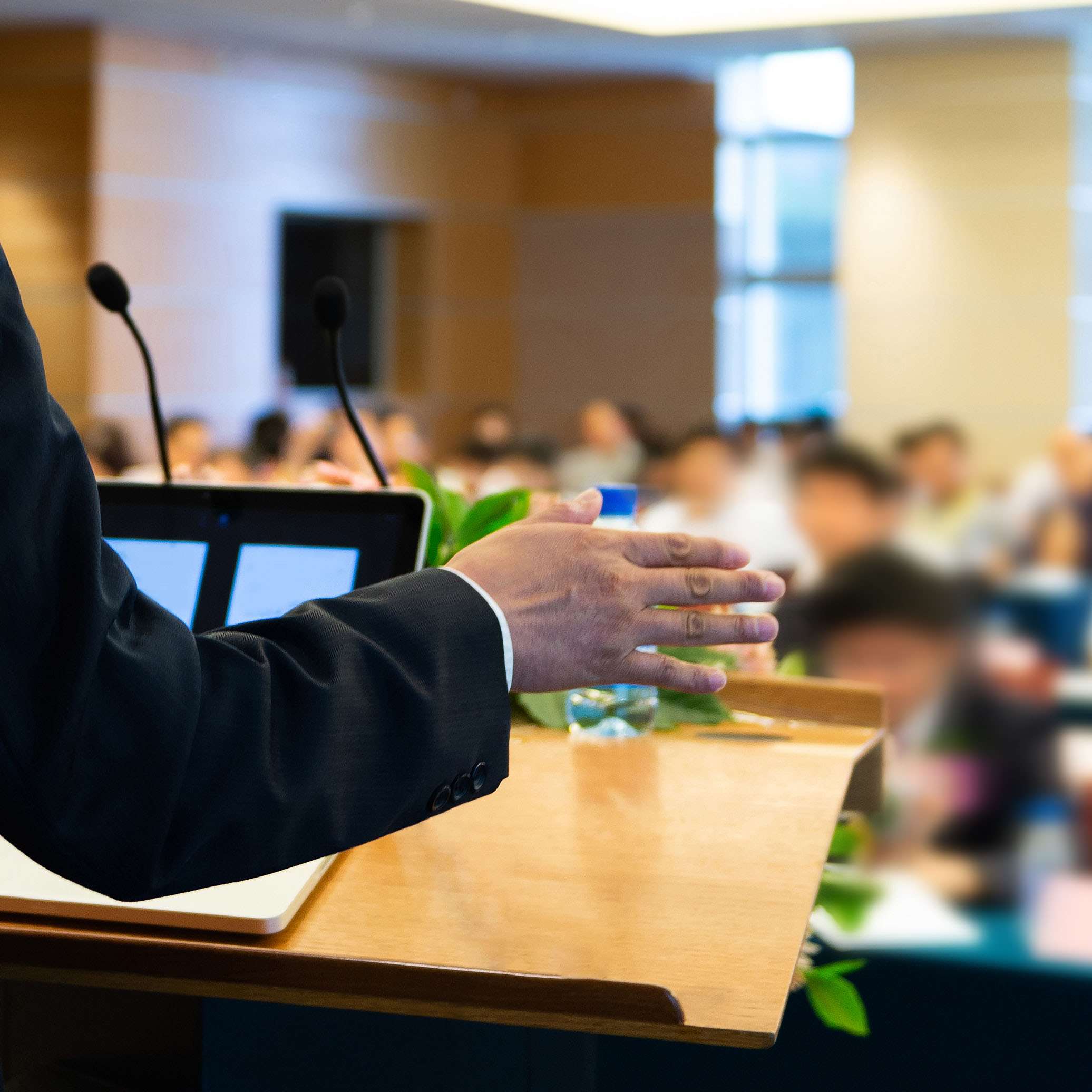 Image of speaker giving lecture to a crowd of people